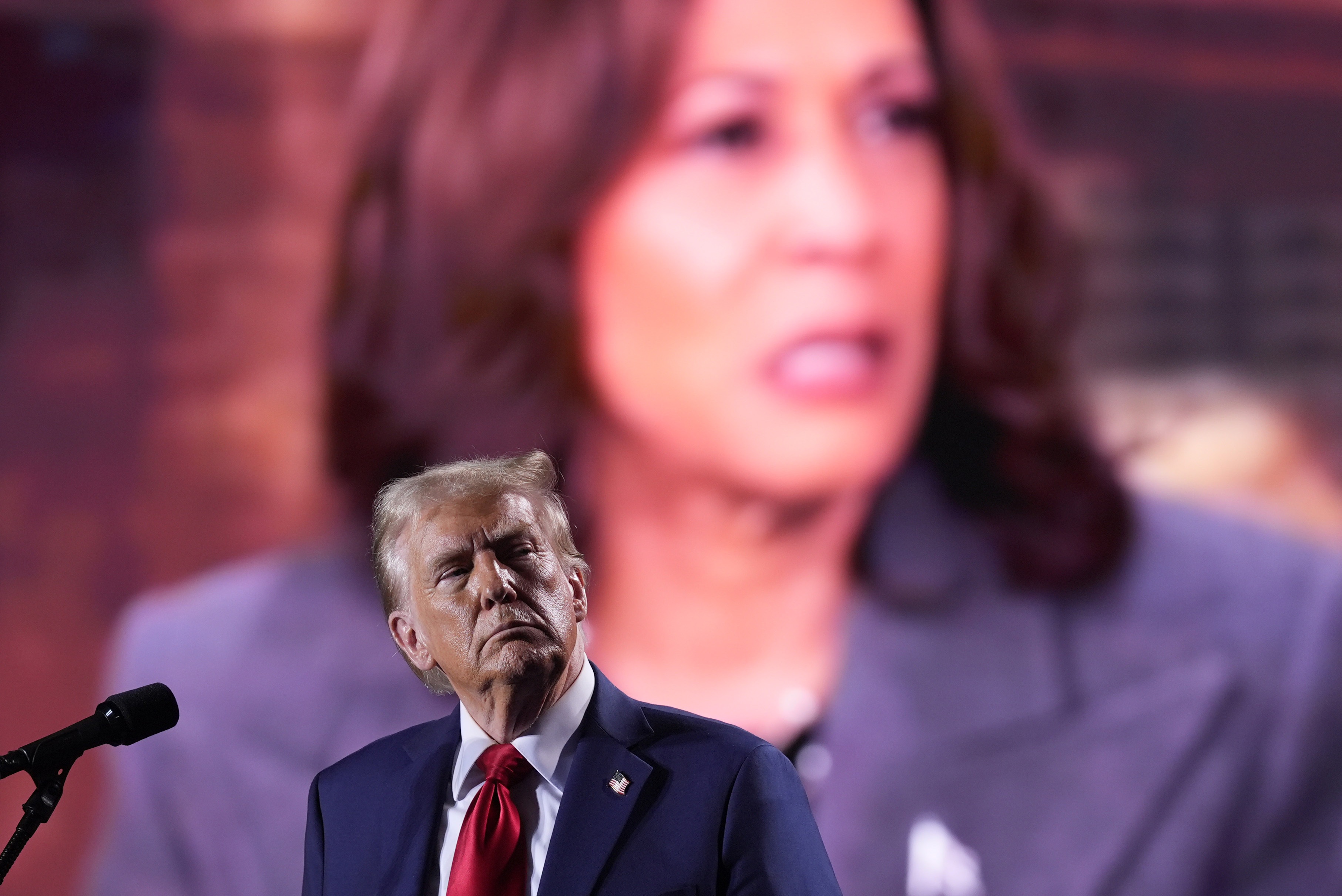 Republican presidential nominee and former President Donald Trump watches as a video featuring Vice President Harris, the Democratic presidential nominee, plays during a campaign event on Oct. 18 in Detroit. (AP)
