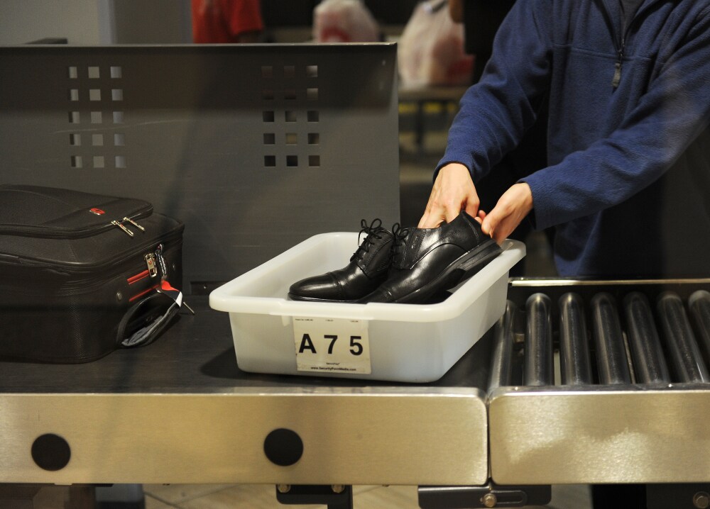 An air traveler puts his shoes in a bin before passing through a Transportation Security Administration (TSA) security checkpoint at Los Angeles International Airport in 2014. (AFP via Getty Images)