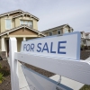 A for sale sign is posted in front of a home in Sacramento, Calif.