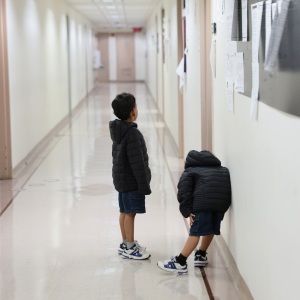 Children wait outside of an immigration court at the Jacob K. Javits Federal Building on July 31, 2026 in New York City. More than 1,400 migrant children across New York, including more than 700 in New York City, are set to lose legal representation as a $200 million federal contract with the Acacia Center for Justice expires. The nonprofit oversees legal services for unaccompanied migrant children and estimates the funding loss will affect more than 24,000 children nationwide. (Photo by Michael M. Santiago/Getty Images)