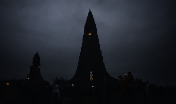 The Hallgrímskirkja church is seen in the dark during a total solar eclipse on a cloudy day in Reykjavik, Iceland.