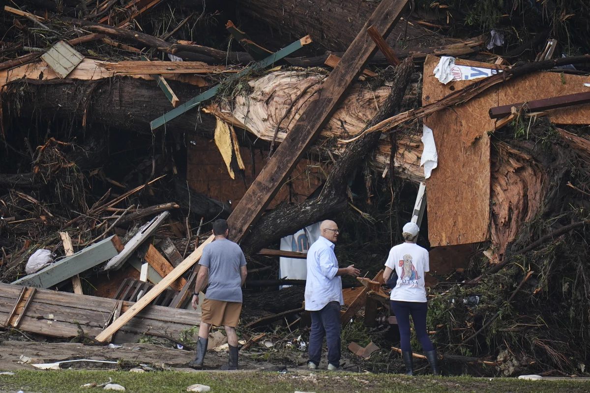 People look at debris on the banks of the Guadalupe River after a flash flood swept through the areain Hunt, Texas.