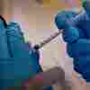 A pharmacist administers a COVID-19 vaccine.