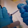 A pharmacist administers a COVID-19 vaccine.