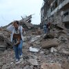 Residents walk amid the rubble of a building damaged in earthquakes the previous day in Catia La Mar, Venezuela.