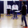 People stand in voting booths that have a U.S. flag on the side of them.