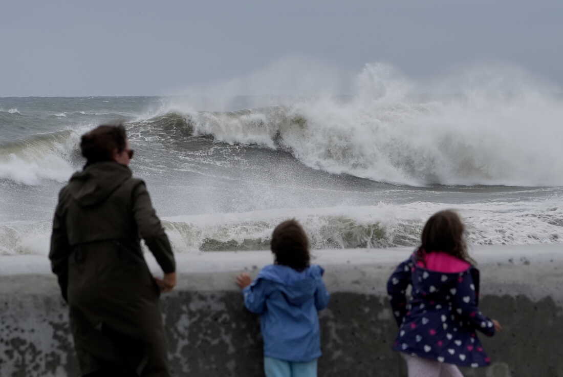 Spectators watch wave break during a nor'easter storm on Saturday in Hampton, N.H.