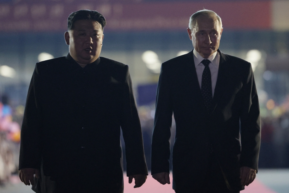 In this pool photograph distributed by the Russian state agency Sputnik, Russian President Vladimir Putin, right, and North Korean leader Kim Jong Un walk during a farewell ceremony upon Putin's departure at the Sunan International Airport in Pyongyang on June 19. (Pool/AFP via Getty Images)