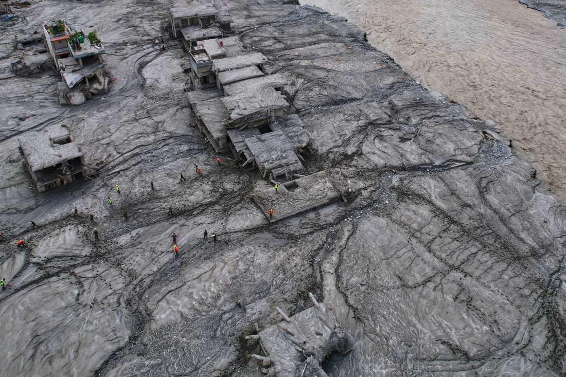 A drone view shows rescue workers inspect the area and damaged structures following recent flash flooding along the Trishuli River in the Devighat area of Nuwakot district, Nepal, Saturday, Aug. 29, 2026. (AP Photo/Rajesh Kumar Singh)
