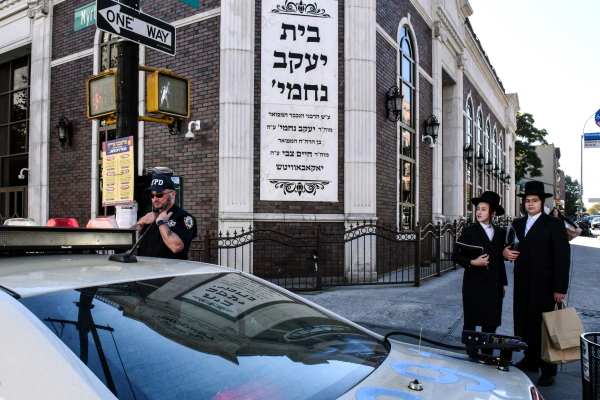 A member of the New York Police Department patrols in front of the synagogue Congregation Bais Yaakov Nechamia Dsatmar on Oct. 13, 2023 in the Williamsburg neighborhood in the borough of Brooklyn in New York City.