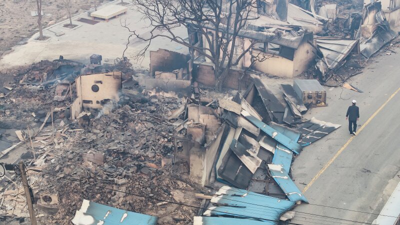 A man walks near a burnt-out house in a damaged village in Yeongyang, South Korea on Wednesday.