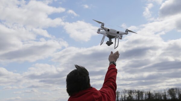 Person operating a drone near a body of water.