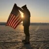 Christophe Receveur, of France, unfurls an American flag he bought six months ago in Gettysburg, Pa., to mark D-Day on Thursday on Utah Beach, Normandy. 