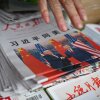 FILE - Copies of the People's Daily newspaper with a front page photo and headline which reads "Xi Jinping holds talks with US President Trump", are displayed at a news stand in Beijing on May 15, 2026. Trump said he had made "fantastic trade deals" with China's Xi Jinping, as the pair met on May 15 at final talks of a superpower summit that according to the US leader has also reaped a Chinese offer to help open the Strait of Hormuz.