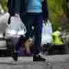 A person carries bags of fresh water after filling up from a tanker at a distribution site in the aftermath of Hurricane Helene on Wednesday in Asheville, N.C. 