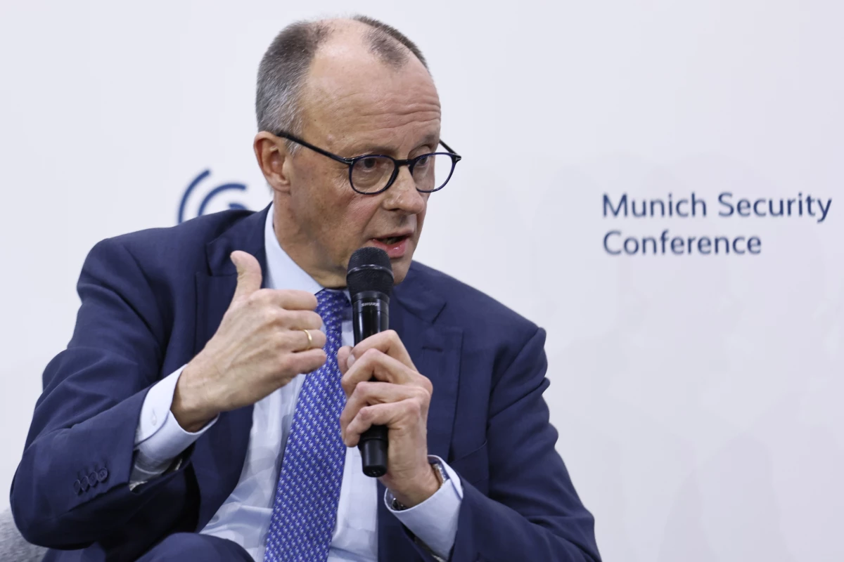German Chancellor Friedrich Merz speaks with Wolfgang Ischinger (not pictured), chairman of the Munich Security Conference, after delivering his speech at the conference on Feb. 13.