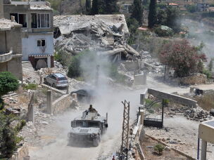 A Lebanese military vehicle drives past homes damaged during the war in the southern village of Zawtar al-Gharbieh, Lebanon, Monday, July 27, 2026.