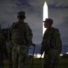 Members of the National Guard patrol at the National Mall with the Washington Monument in the background.