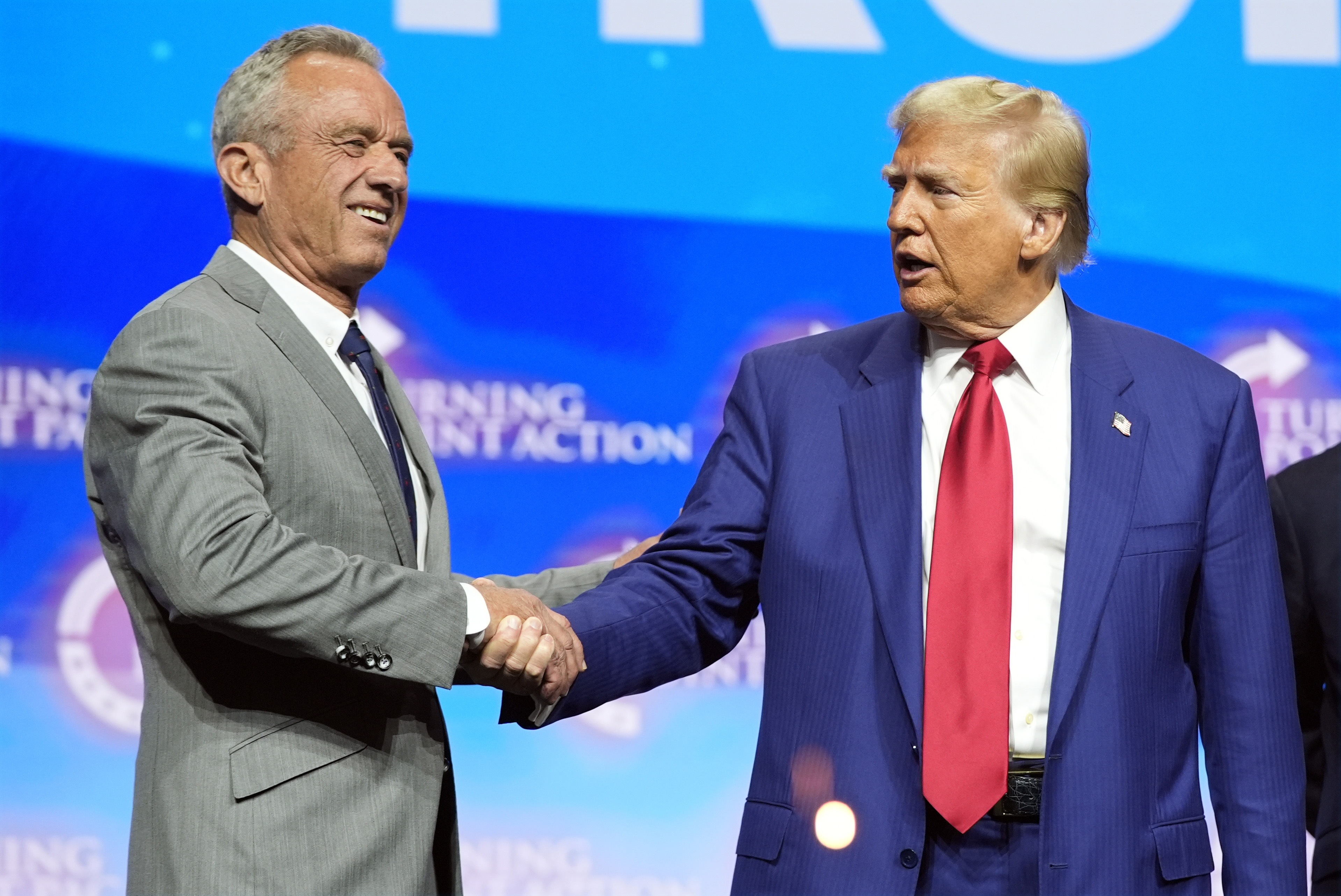 President-elect Donald Trump shakes hands with Robert F. Kennedy Jr., at a campaign rally in October. Kennedy, who is skeptical of vaccines, is among Trump's advisors on health. (AP)