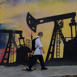A pedestrian walks past a mural featuring oil wells in Caracas, Venezuela, Saturday, Aug 29, 2026, a day after President Donald Trump announced a deal giving the United States a stake in Venezuela’s oil reserves. (AP Photo/Pedro Mattey)