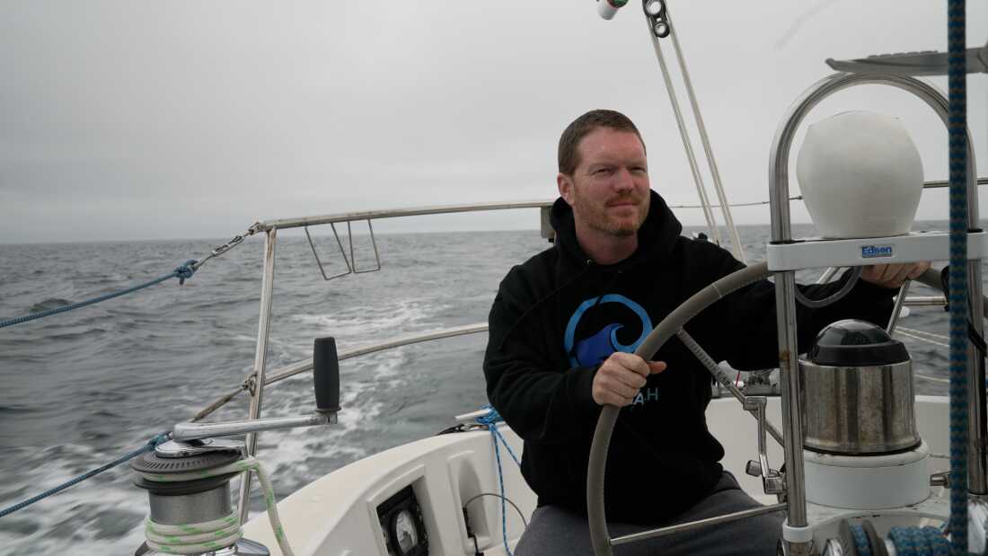 Sailor Matt Rutherford at the helm of a sailboat. He hopes to be the first to circumnavigate the Arctic Circle alone.