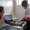 A health worker measures the blood pressure of a woman at Penda Health Clinic Umoja II in Nairobi, Kenya, where researchers have tested an AI tool that can check out the notes taken by clinicians.