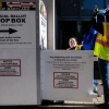 Election workers remove ballots from a drop box outside the polling center at the Silver Spring Civic Building on Oct. 22 in Silver Spring, Md.