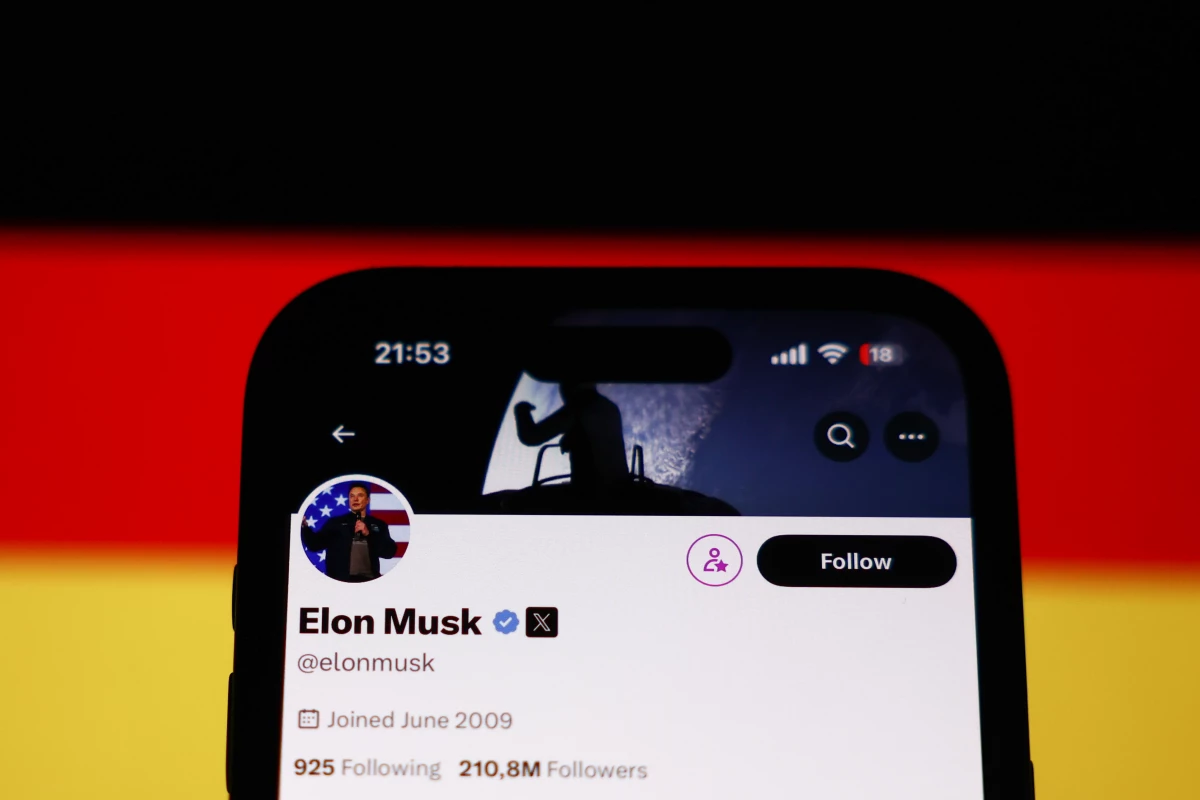 A photo illustration of a German flag displayed on a laptop screen and Elon Musk's account on X displayed on a phone screen.
