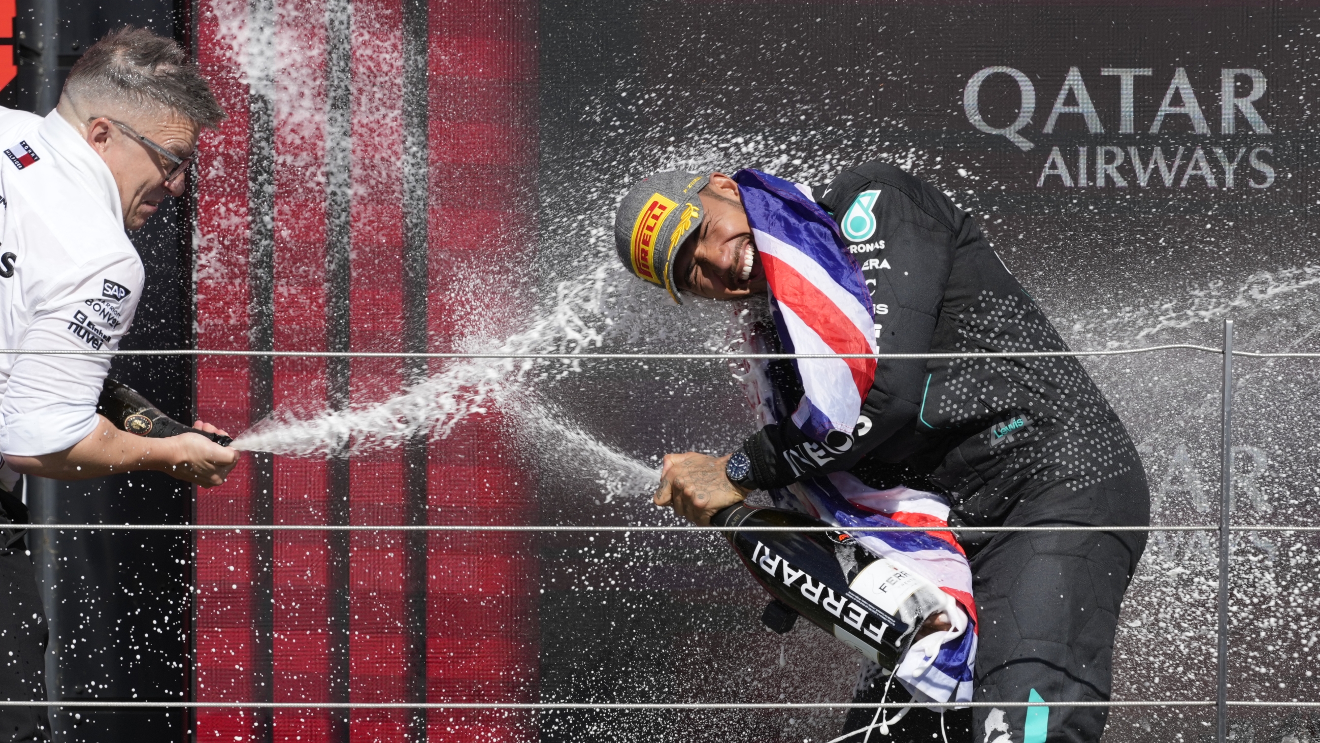Mercedes driver Lewis Hamilton, right, celebrates on the podium after winning the British Formula One Grand Prix race at the Silverstone racetrack in Silverstone, England, on Sunday.