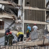 People and rescuers work on the debris of a collapsed building in Caracas after a pair of strong earthquakes struck Venezuela.