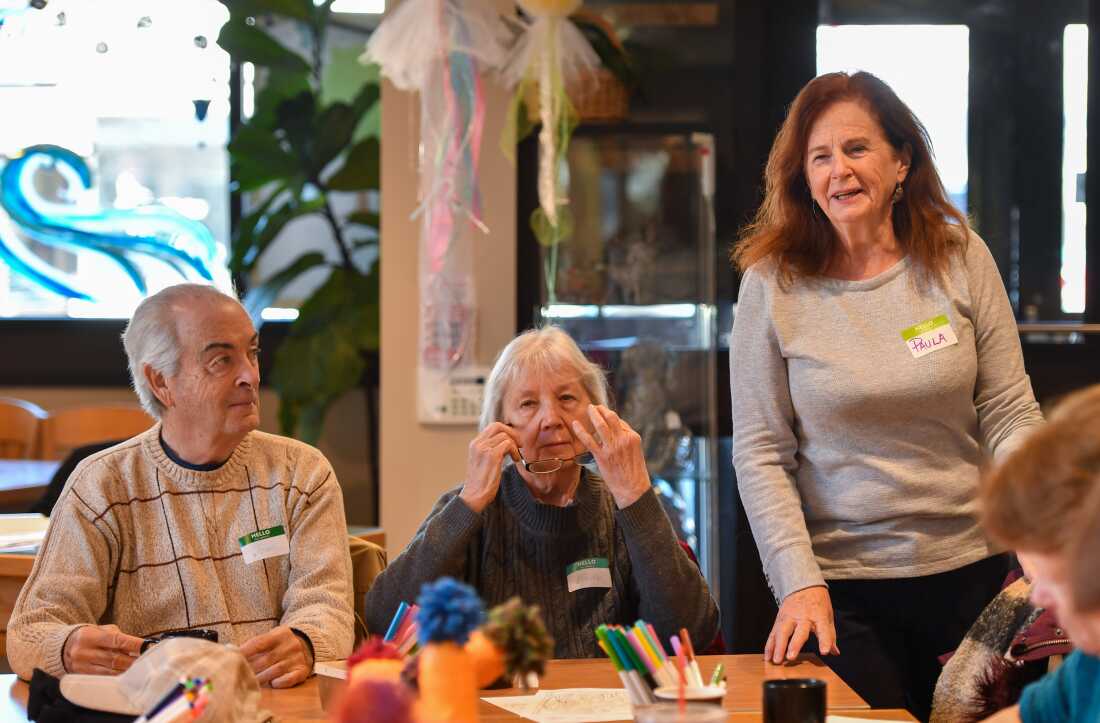 Paula Baille talks with guests at the Gathering Place in Clarks Summit during the Friday memory cafe, while Joe and Barb Edwards listen.