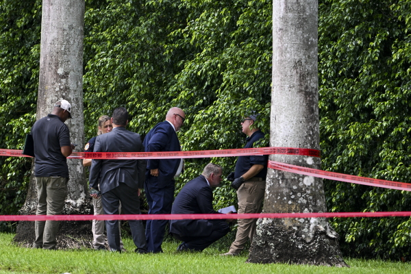 Law enforcement officials work at the crime scene outside the Trump International Golf Club in West Palm Beach, Fla., on September 16, 2024, following the attempted assassination on then-Republican presidential candidate Donald Trump. Ryan Routh is charged in the case and has a federal court hearing on Tuesday in Fort Pierce, Fla.