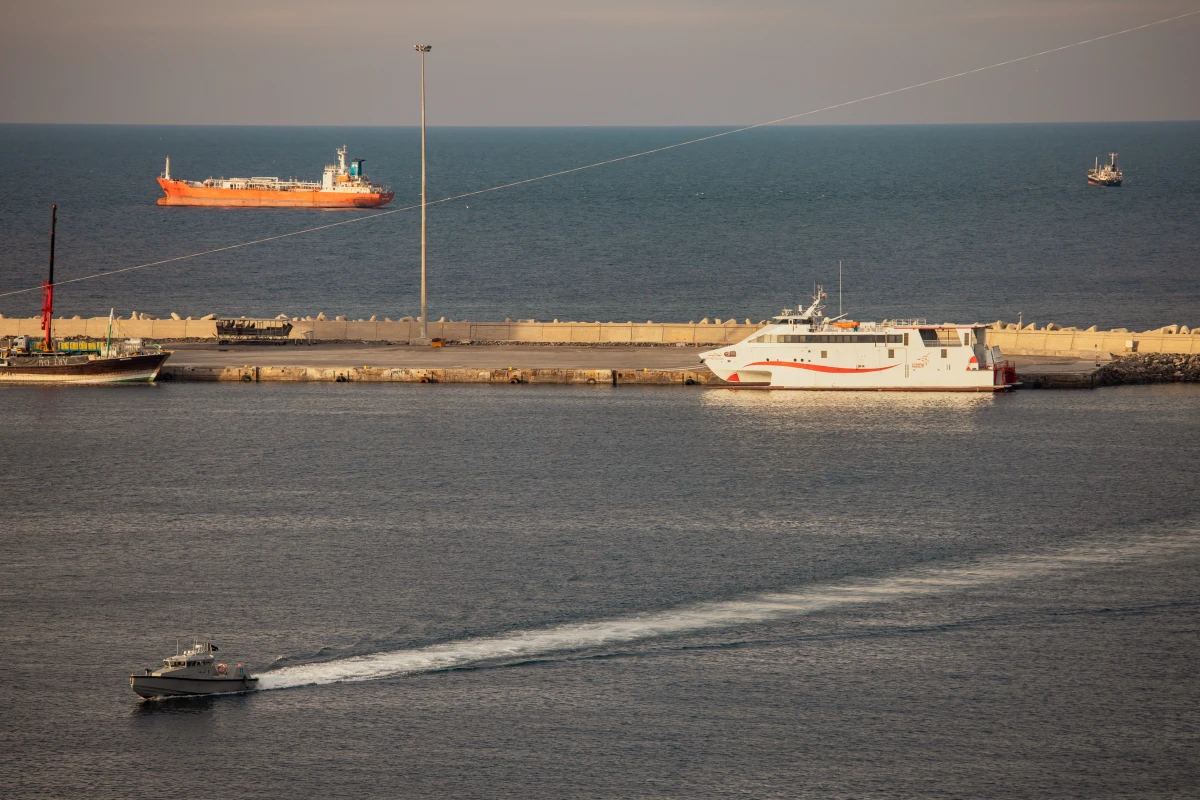 A police speed boat patrols the port as oil tankers and high speed crafts sit anchored near the Strait of Hormuz on March 30 in Muscat, Oman. The war led to the shutdown of tanker traffic through the vital waterway.