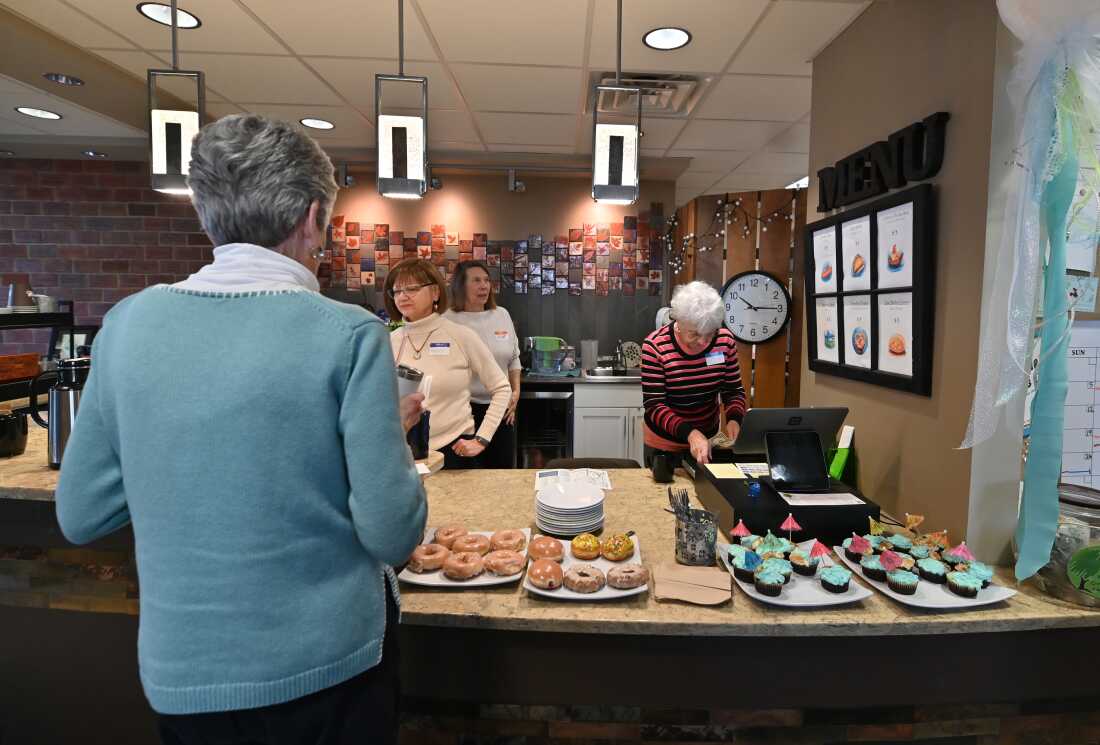 As things get underway at the memory cafe in Clarks Summit, Penn., guests help themselves to breakfast pastries.