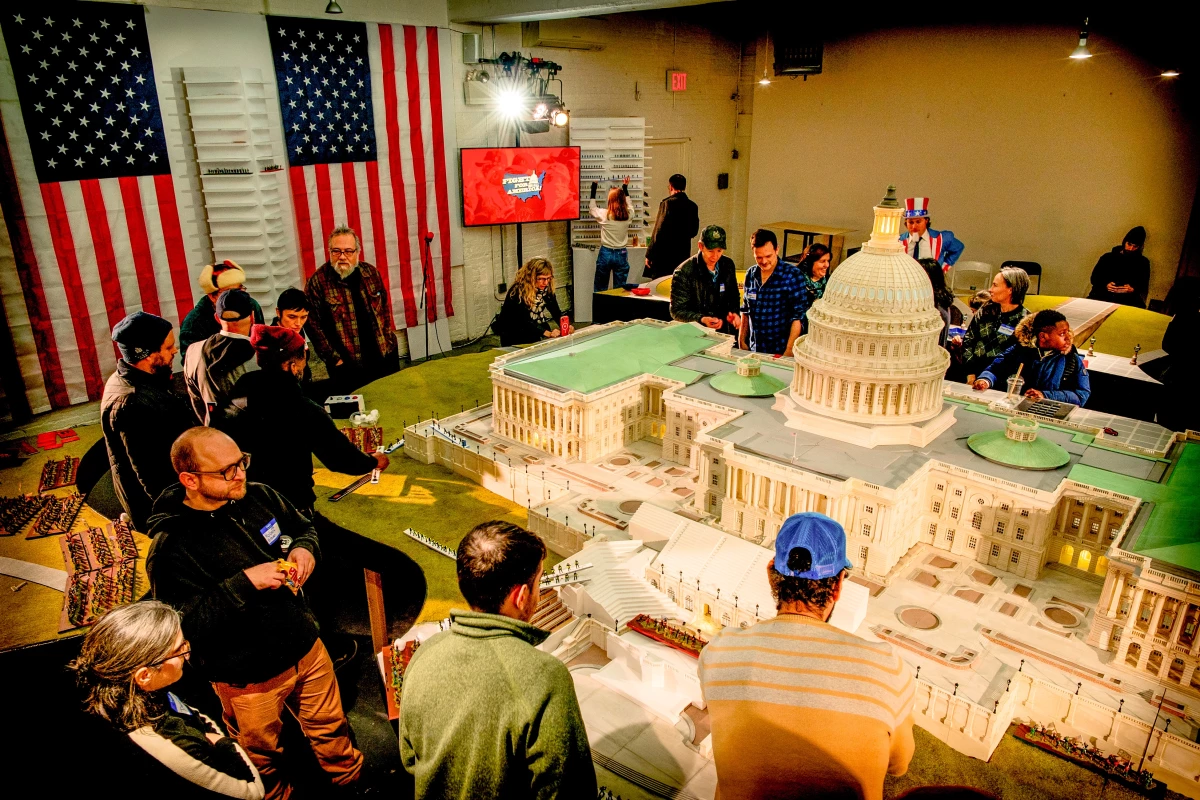 The board — a green lawn and marble steps — surrounds a detailed, nearly 14-foot, plastic replica of the Capitol.