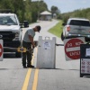 A worker locks the gate to the entrance of Everglades National Park Shark Valley due to the government shutdown on October 01, 2025, in Everglades National Park, Florida. The park will remain open to visitors, but with minimal staffing.
