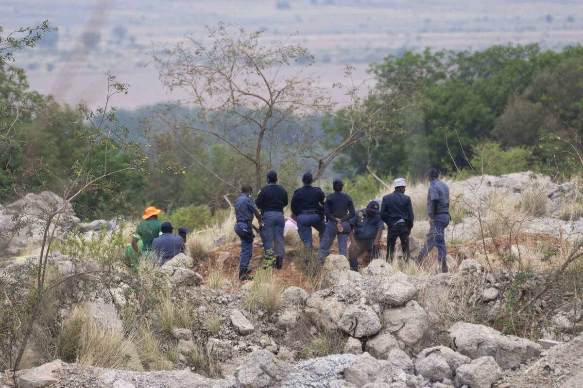 Rescue workers, left, remove a body from a reformed mineshaft where illegal miners are inside in Stilfontein, South Africa on Thursday.