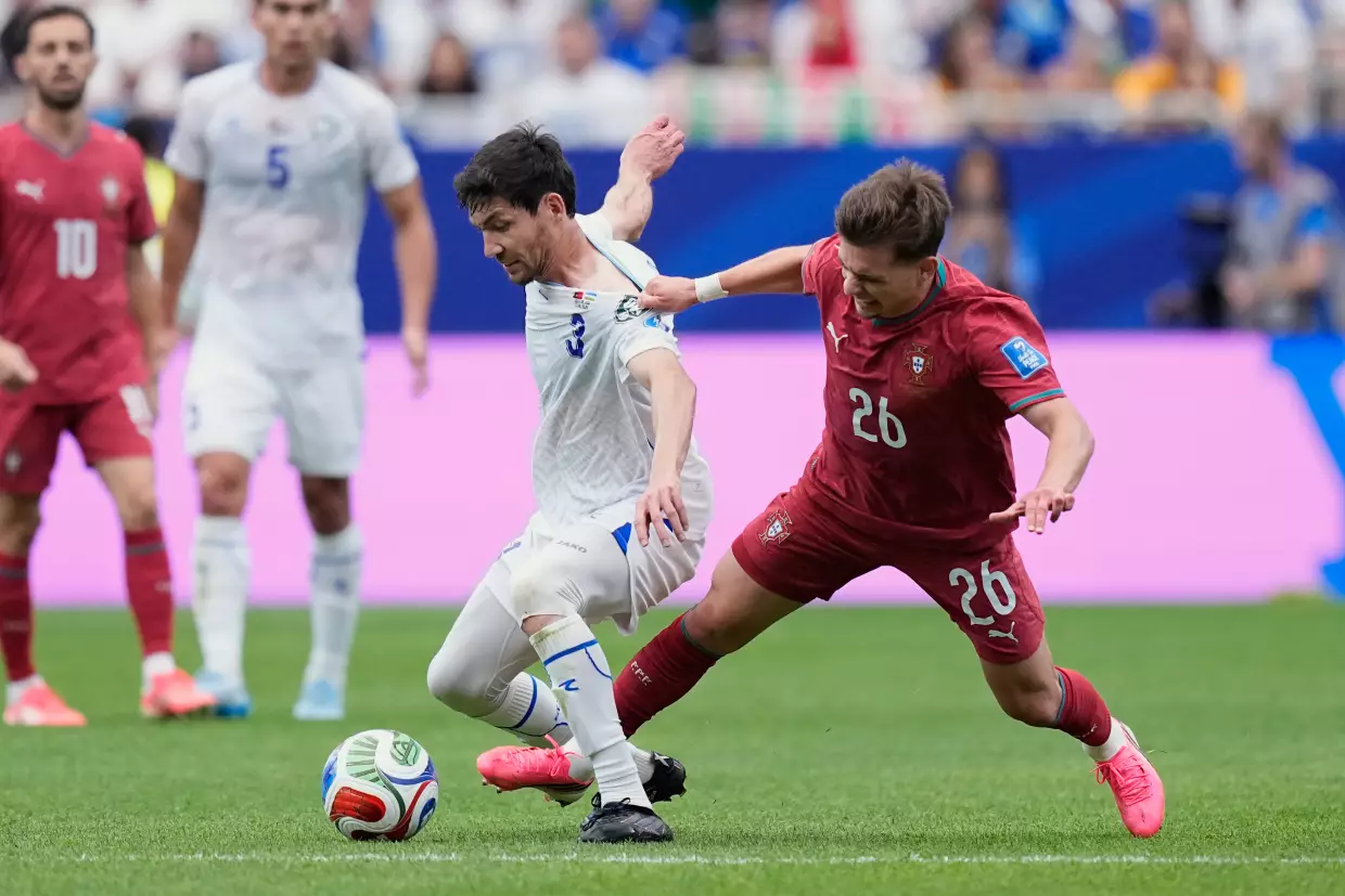 Portugal's Francisco Conceicao, right, vies for the ball with Uzbekistan's Khojiakbar Alijonov during the World Cup Group K soccer match between Portugal and Uzbekistan in Houston, June 23.