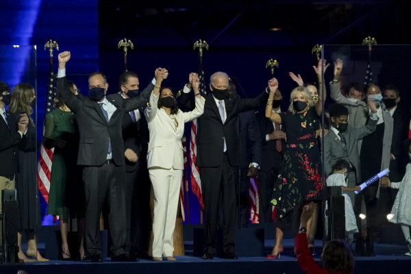 U.S. President-elect Joe Biden, center right, wife Jill Biden, right, U.S. Vice President-elect Kamala Harris, center left, and husband Douglas Emhoff hold hands while wearing protective masks during an election event in Wilmington, Delaware, U.S., on Saturday, Nov. 7, 2020.Sarah Silbiger/Bloomberg via Getty Images