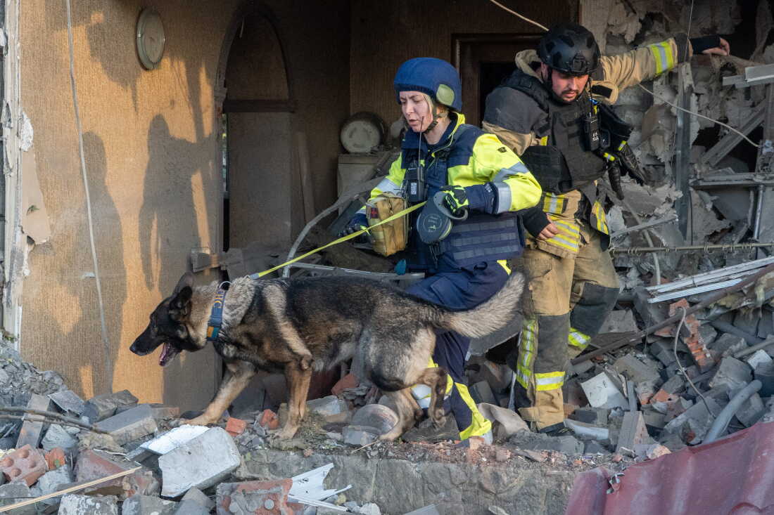 Rescuers with a search dog look for victims among the rubble of a house after a Russian air attack in Kharkiv, Ukraine, Tuesday, Oct. 20, 2026.