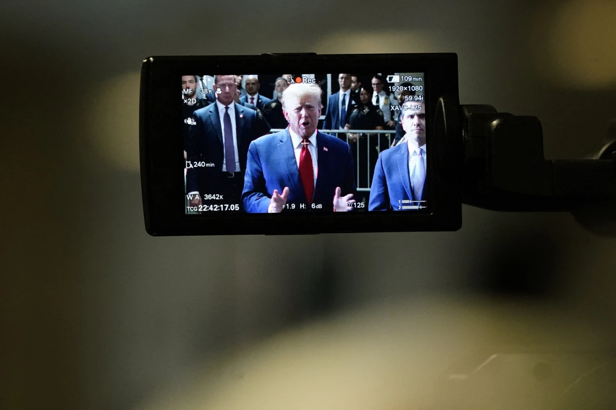 Former President Donald Trump, on a camera monitor, speaks to the press as he arrives at Manhattan Criminal Court on Feb. 15 for a hearing in his case of paying hush money to cover up extramarital affairs.