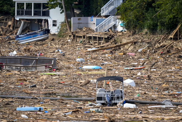 Debris is strewn on the lake in the aftermath of Hurricane Helene, Wednesday, Oct. 2, 2024, in Lake Lure, N.C. In recent years, the home building industry in North Carolina has blocked or slowed efforts to limit home construction on steep slopes and in flood plains.