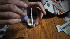 A drug user uses a test strip on Aug. 22, 2018, in New York, to see if fentanyl has been added to heroin, which could increase the risk of overdose.