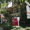 For-sale signs are staked into the ground in front of condominiums for sale in July in Los Angeles.
