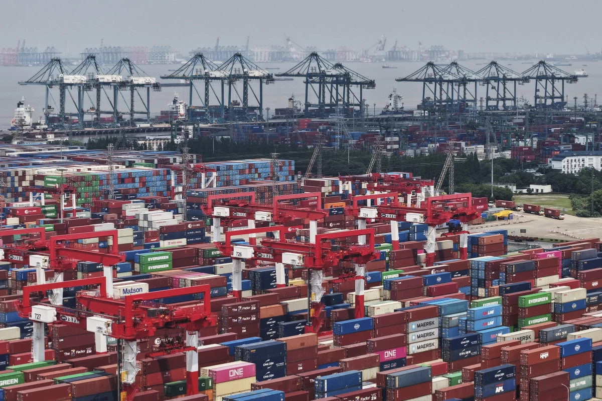 Trucks loaded with containers move through a port in Shanghai, China Monday, June 9, 2025.