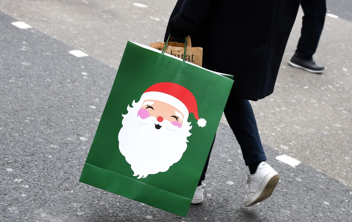 A shopper carries a Christmas-themed bag in London on Dec. 2, 2020.