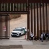 Migrants and asylum seekers wait to be processed by the Border Patrol between the fence at the U.S.-Mexico border seen from Tijuana, Baja California state, Mexico, on June 5, 2024, the day after President Biden issued executive actions that restrict asylum for most migrants.