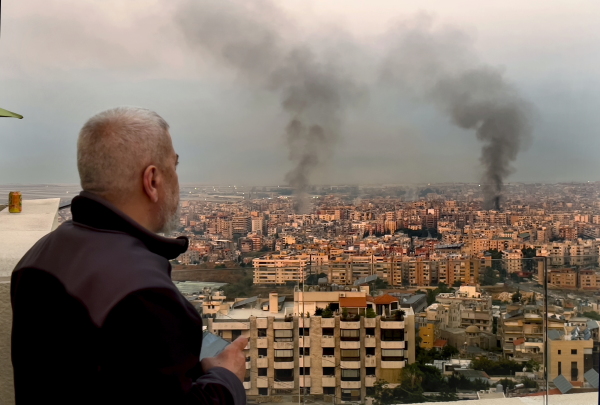 A man looks as smoke rise from Israeli airstrikes in Dahiyeh, Beirut, Lebanon, early on Sunday.