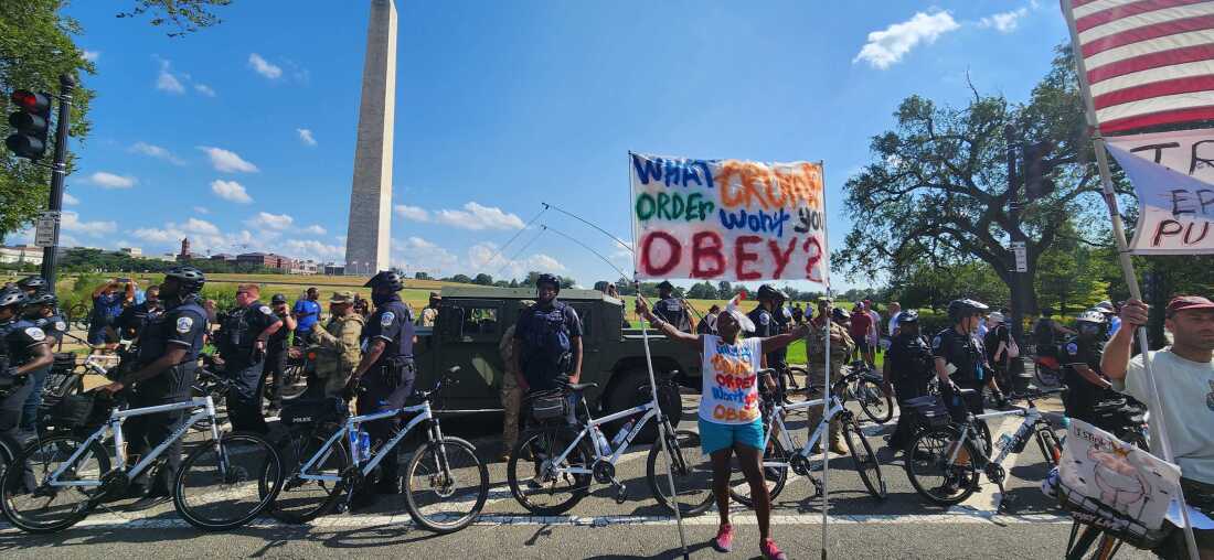 A protester stands in front of Metropolitan Police Department officers and federal law enforcement on Aug. 16