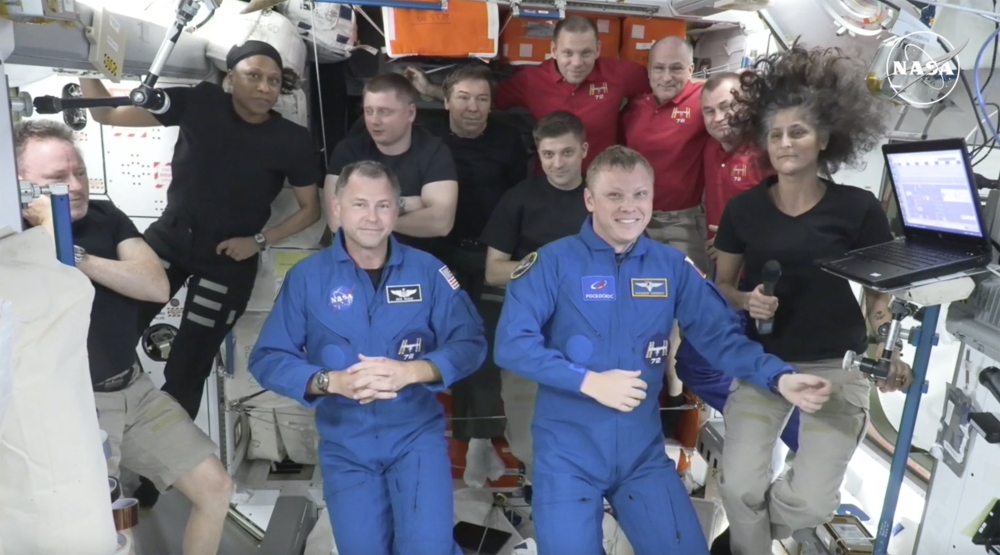 Butch Wilmore, far left, and Suni Williams, far right, welcome Nick Hague, front left in blue, and Alexander Gorbunov, front right in blue, on Sunday. Behind them, from left in black, are NASA's Jeanette Epps, Russia's Alexander Grebenkin, NASA's Mike Barratt and NASA's Matthew Dominick. From left, in red, are Russia's Ivan Vagner, NASA's Don Pettit and Russia's Alexei Ovchinin. (AP)